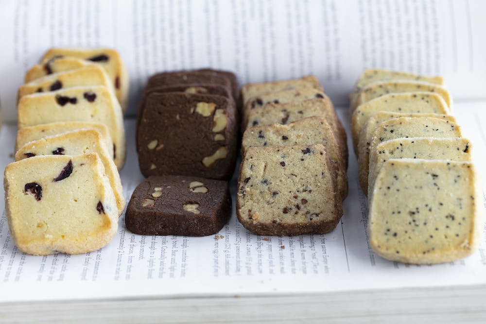 a piece of cake covered in chocolate sitting on top of a cutting board